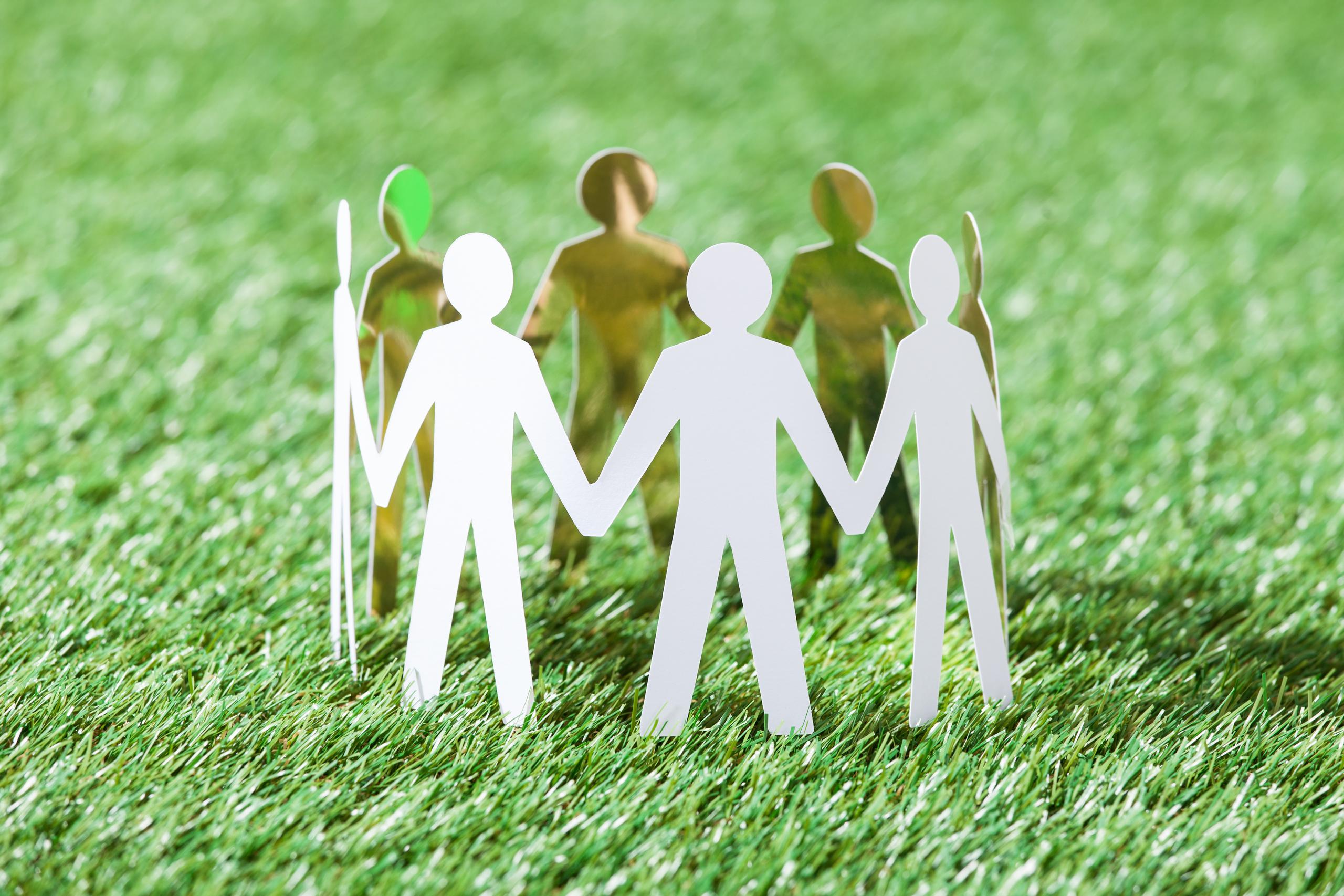 Team Of Paper People On Grassy Field